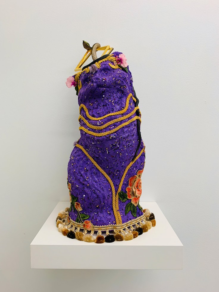 purple sculpture of cat with found objects