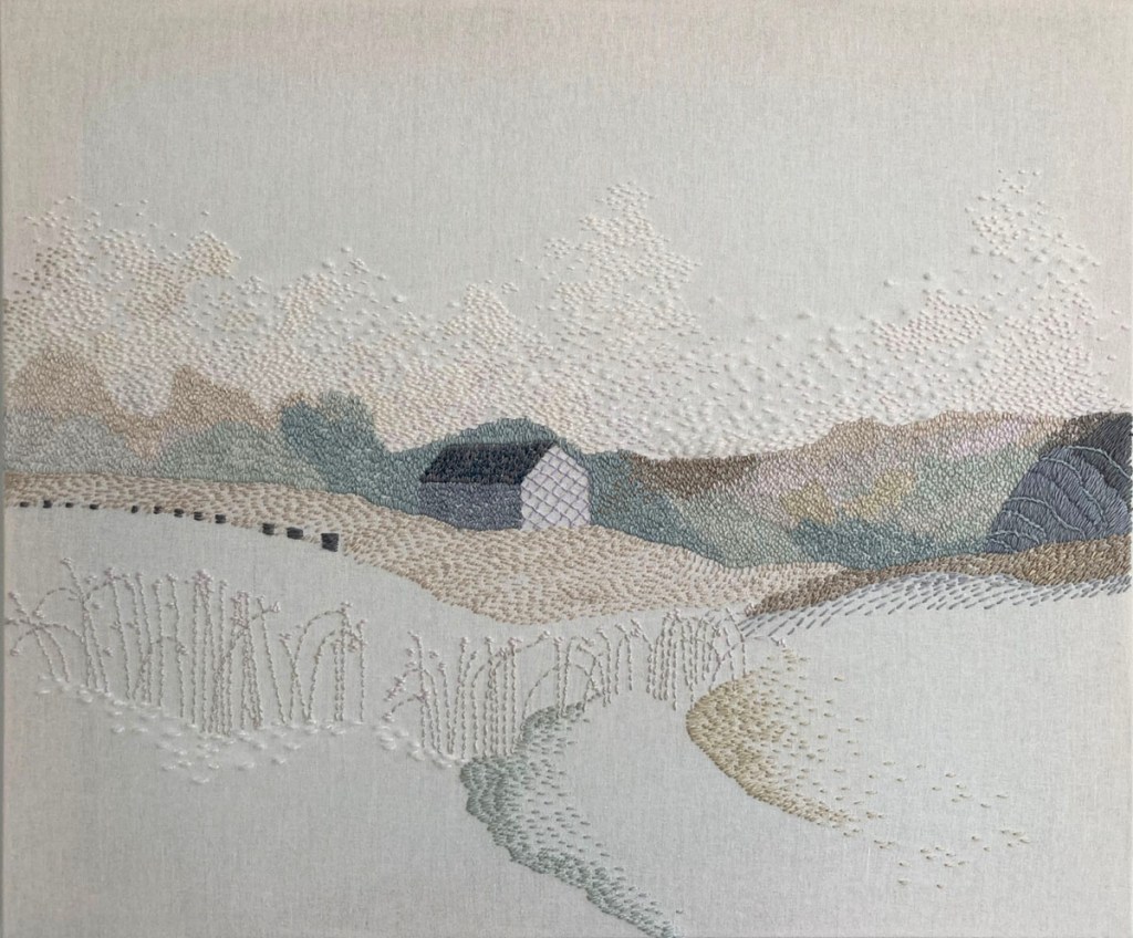 Embrodiery with soft colors on linen, depicting a house and hills and a field