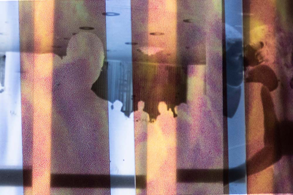 Vertical banded image with Xray like layered images of figures and a gathering at a table